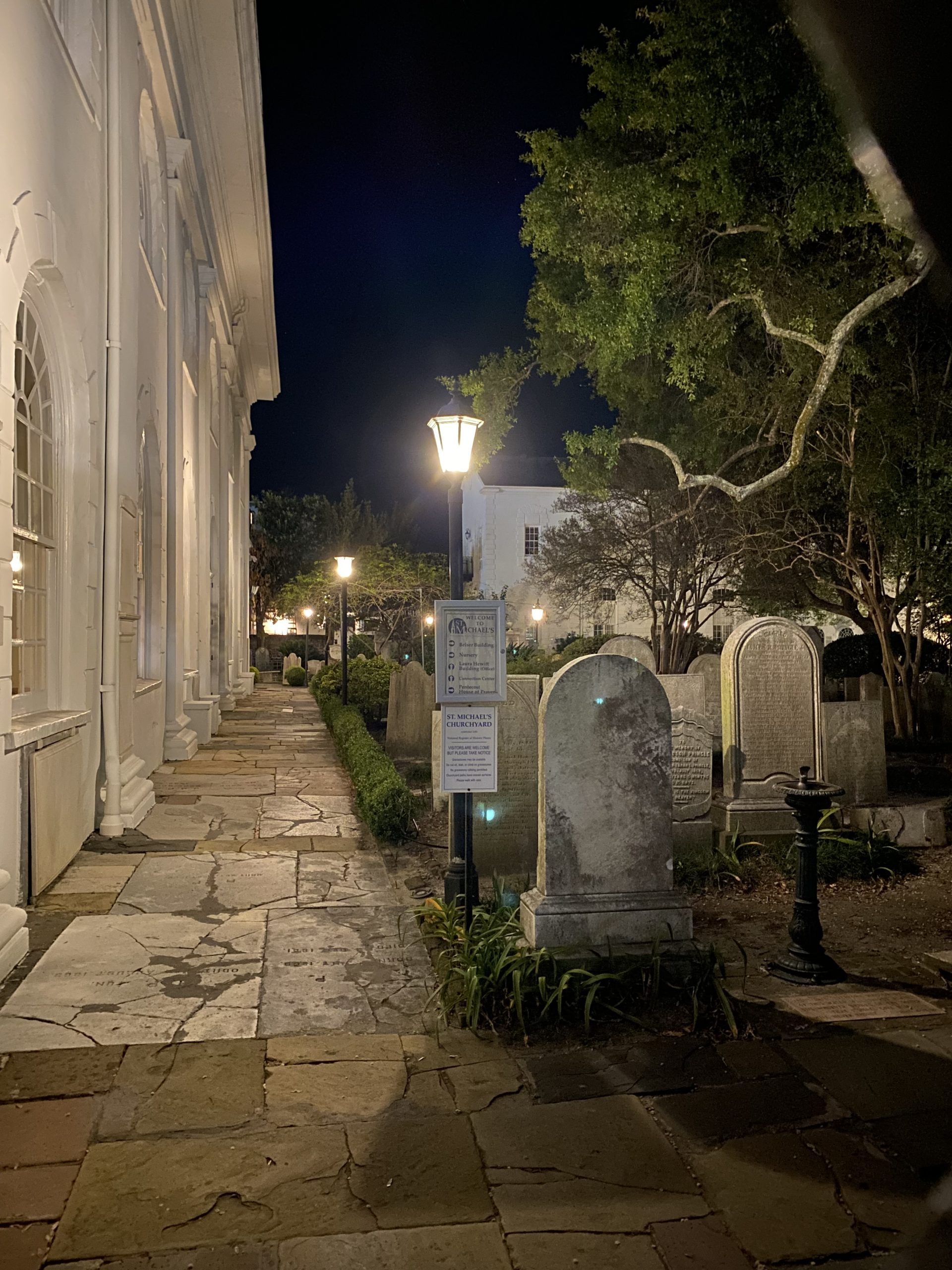Nighttime in Charleston with a view of the side of a church and an old cemetery as part of a ghost tour fun things to do and see in Charleston