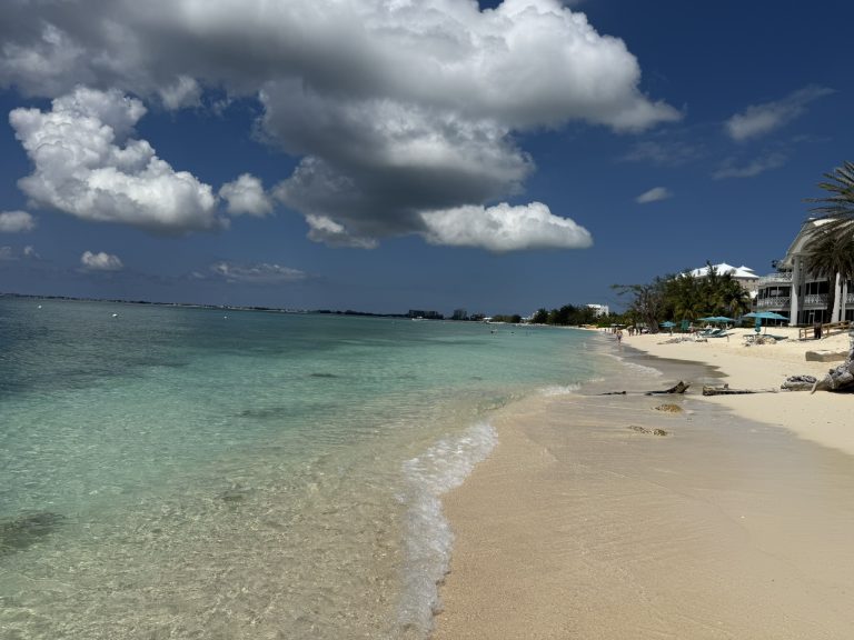 White sand and turquoise water. Blue sky with big white clouds at the Grand Cayman Island