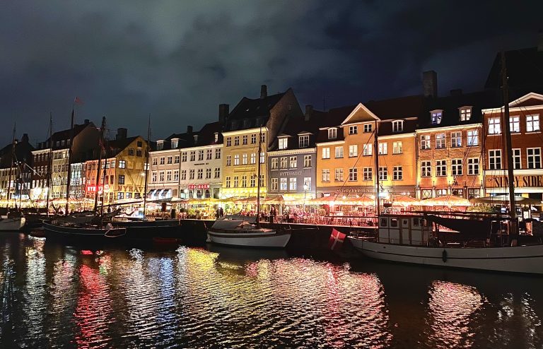 Exploring Copenhagen in October Nyhavn with canal at night light up in various colors