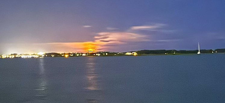 Hidden gems in Charleston full moon kayak tour view of pink moon rising over Folley beach in the distance as seen from a kayak in the marsh waters