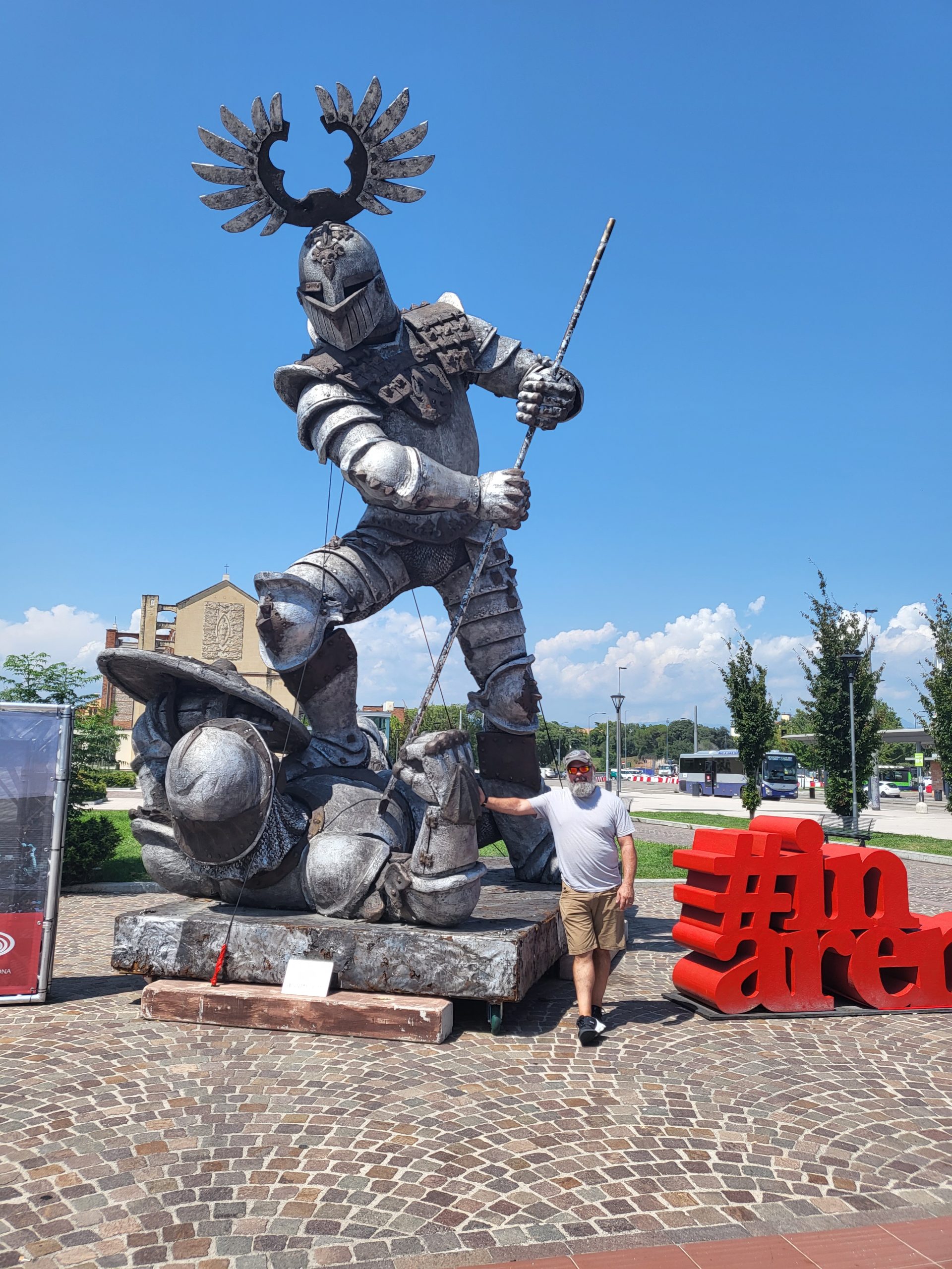 Mark standing with giant conqueror statue outside of Verona, Italy train station.