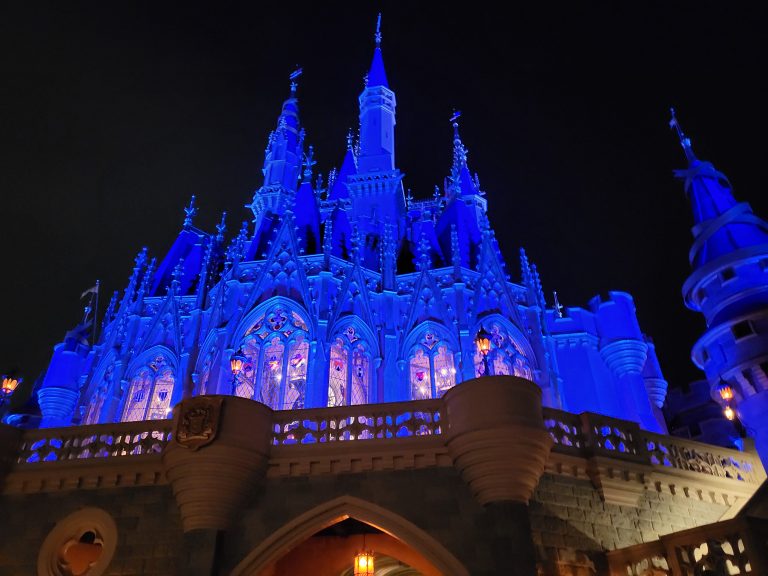 Disney World close-up image of the side of the Disney Castle, light up in blue lighting during the best times to visit Disney