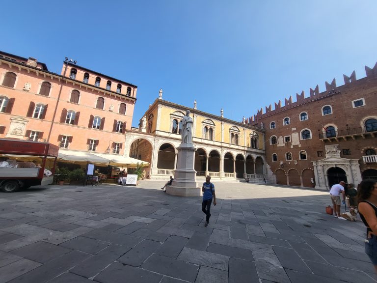 Inside a plaza in a small Italian village looking at the colorful buildings that surround the plaza