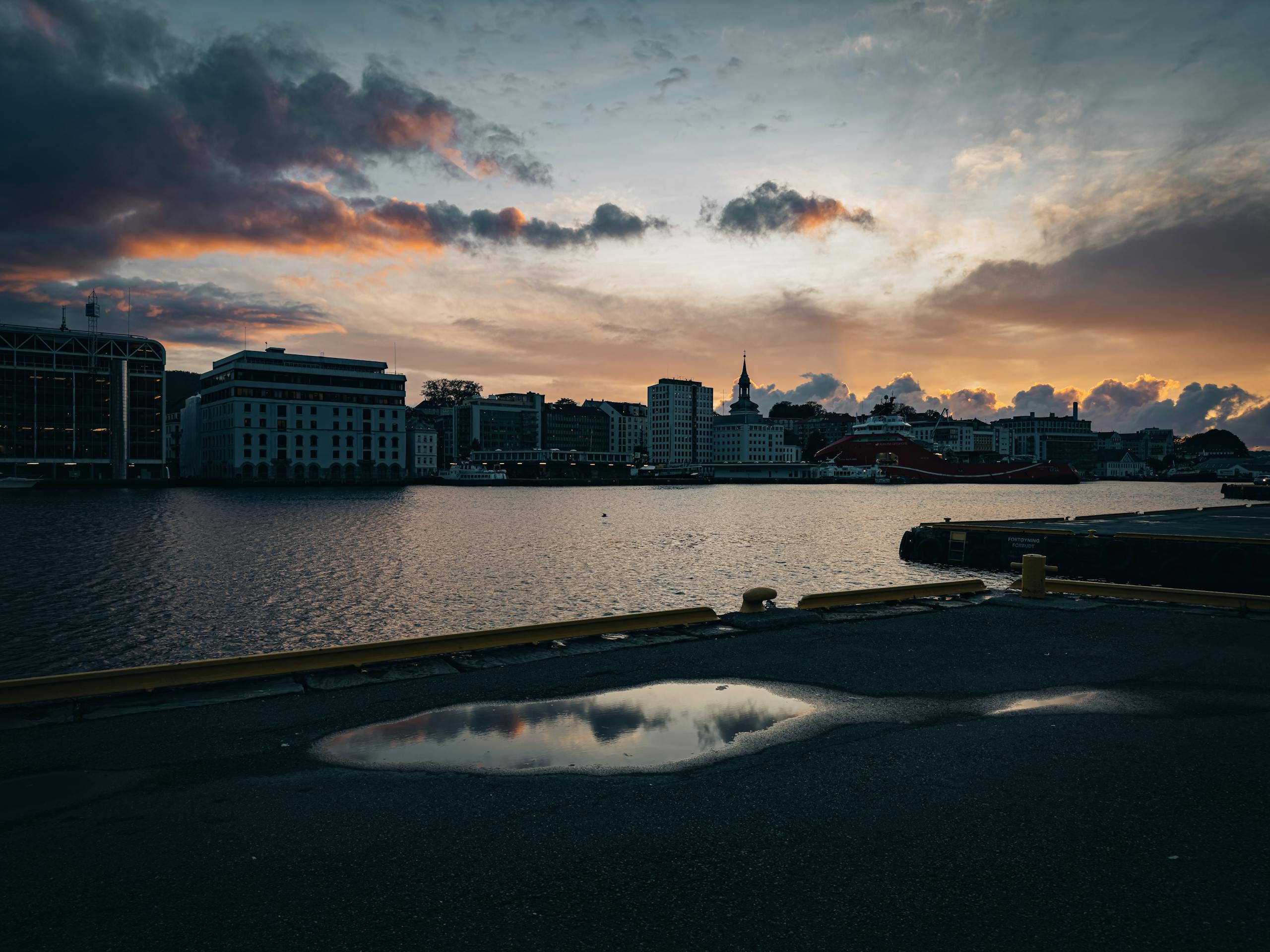 A breathtaking view of the city skyline at sunset with vibrant skies reflecting in the river.