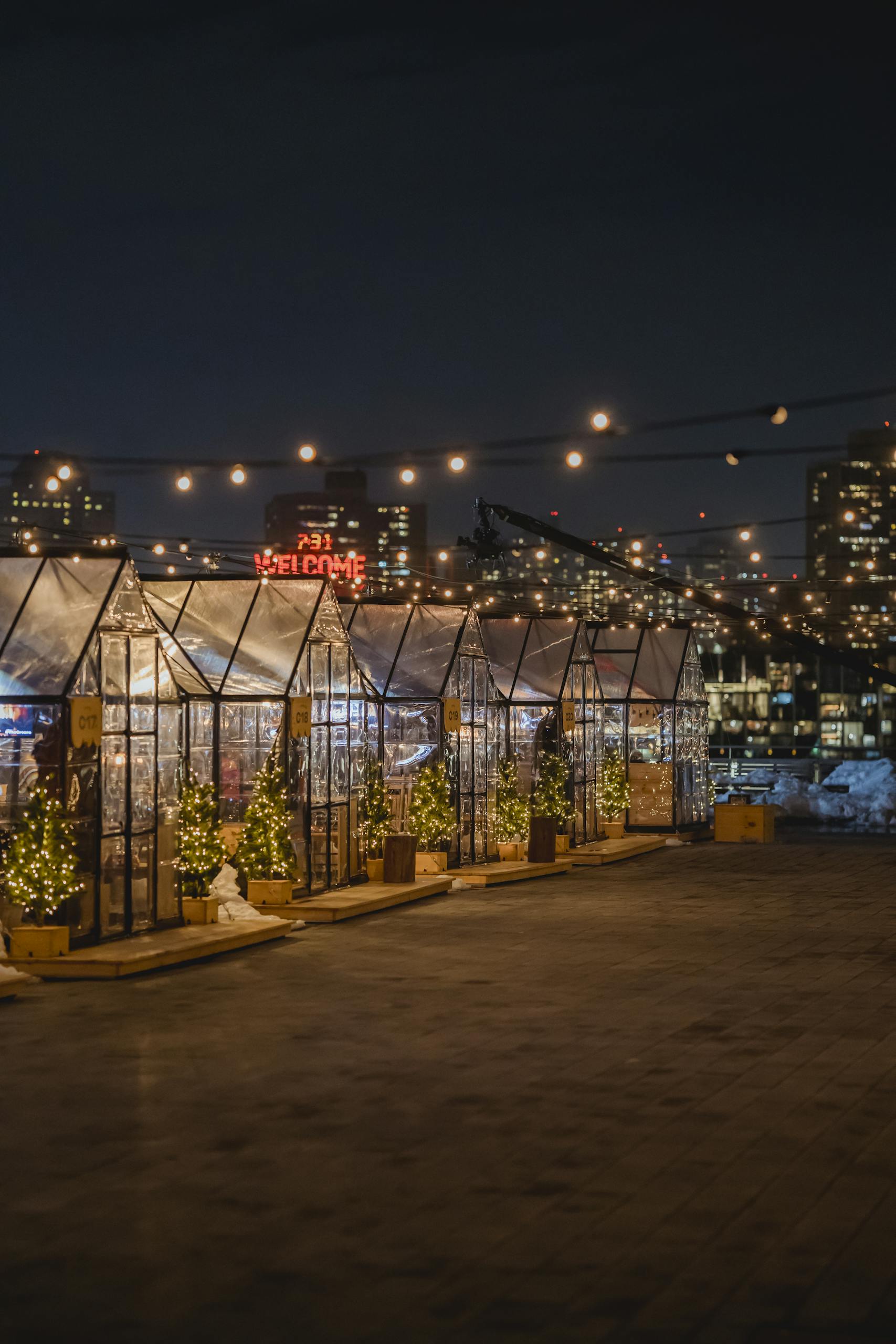 Beautifully illuminated Christmas market stalls at night, with festive lights and decorations.