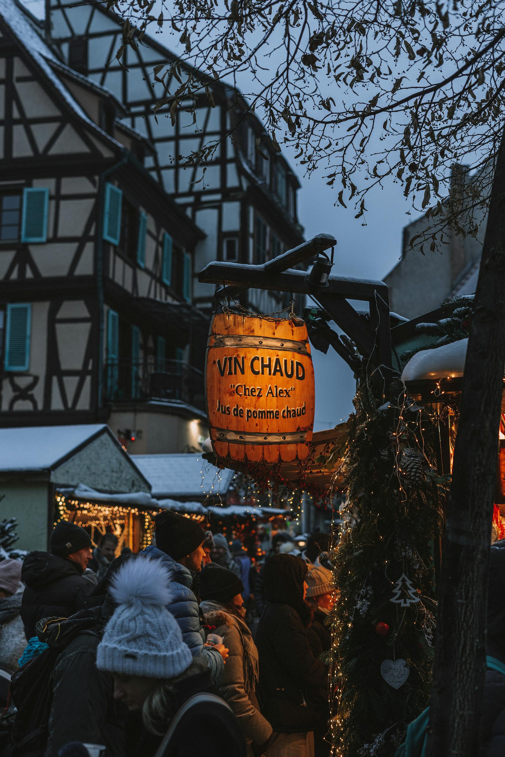 Capture the festive spirit at a bustling Christmas market in the evening snow.