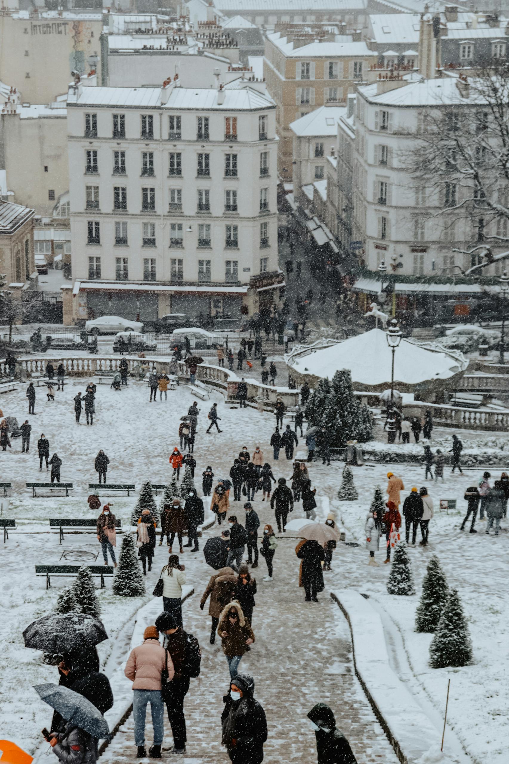 People walking in a snow-covered Paris park during winter