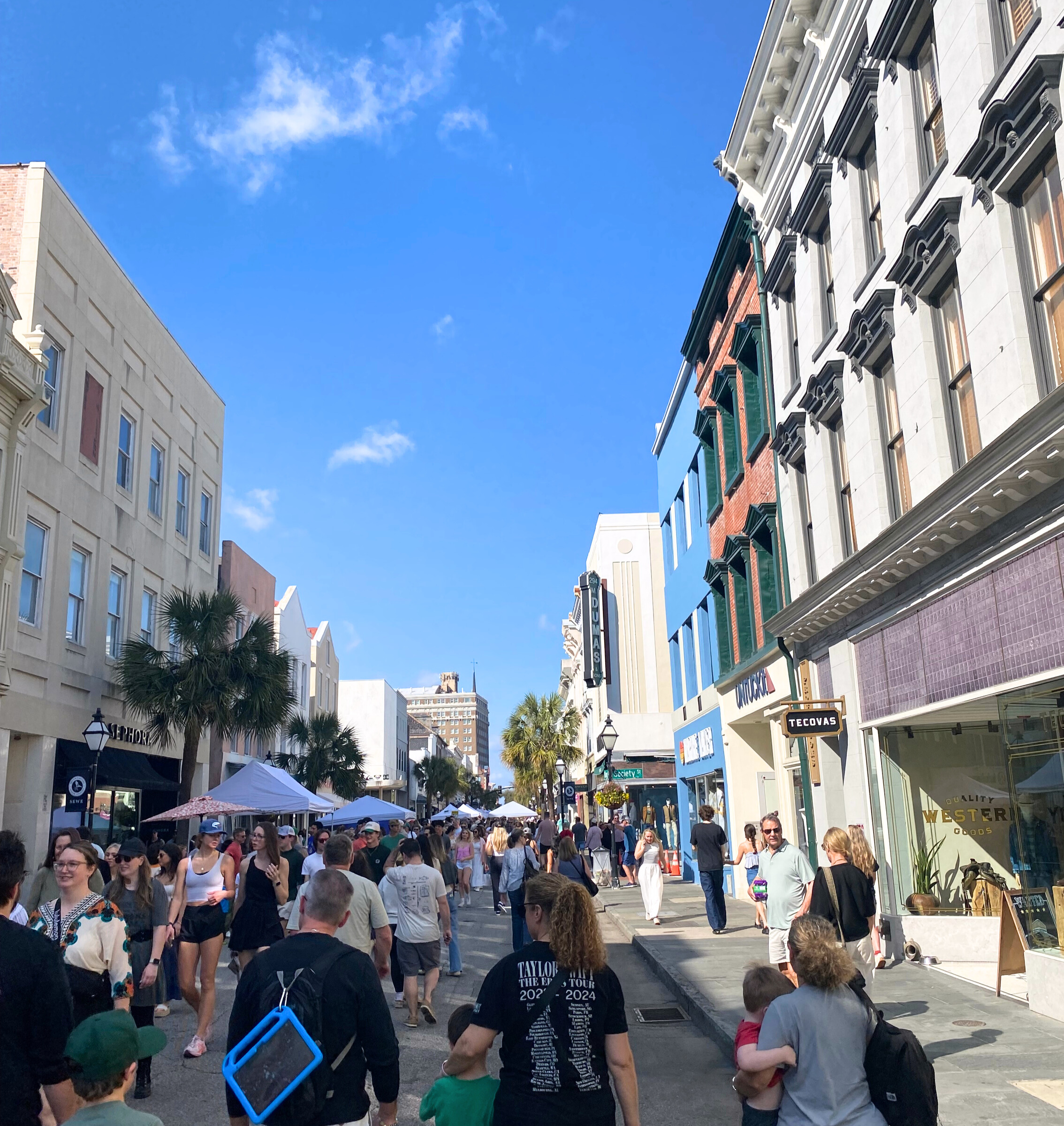 People walking down King Street on the street during second Sunday on a bright sunny day in Charleston, SC