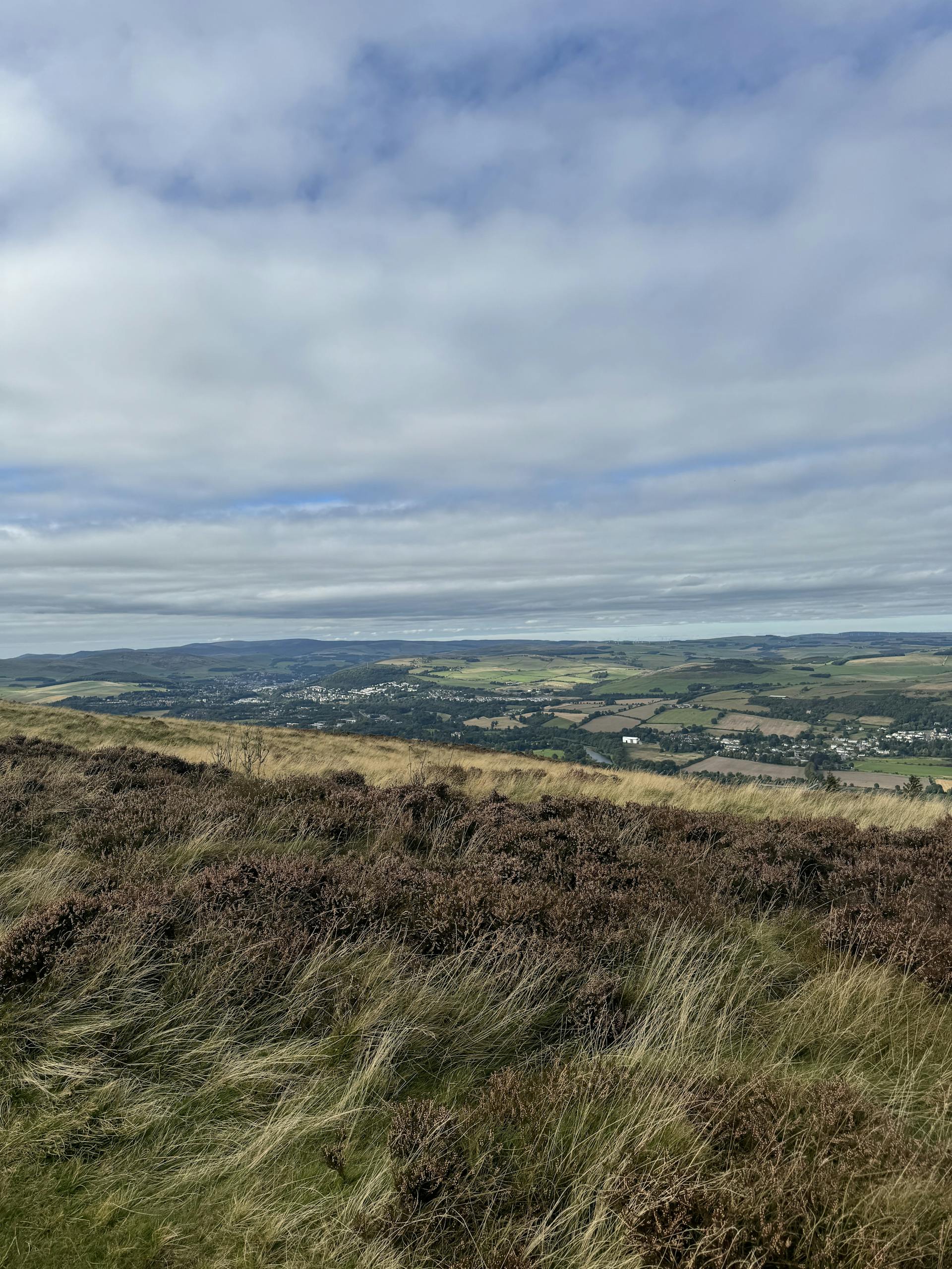 Breathtaking autumn landscape of the rolling hills in Melrose, Scotland with dramatic clouds in the best day trips from Edinburgh.