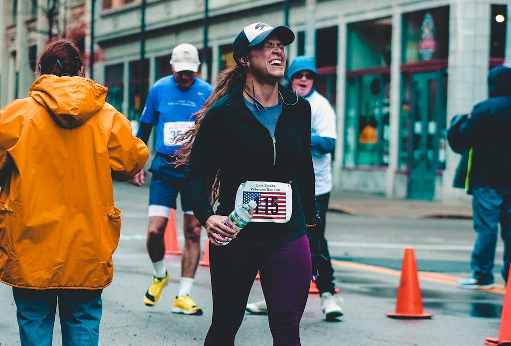 A woman runner triumphantly completes a race in Charleston holiday tuns