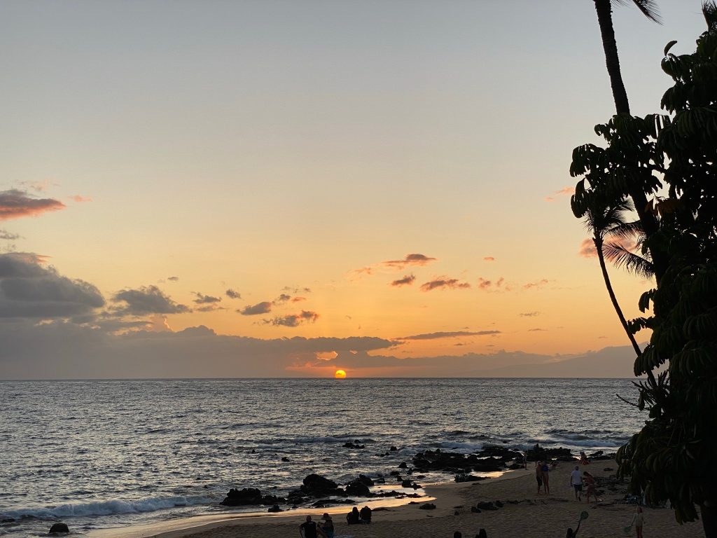 The sun setting into the ocean on a beautiful night in Maui