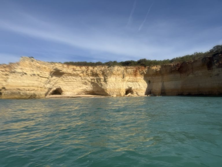 In the best beaches in Algarve, Portugal, beautiful golden limestone cliffs as seen from the water