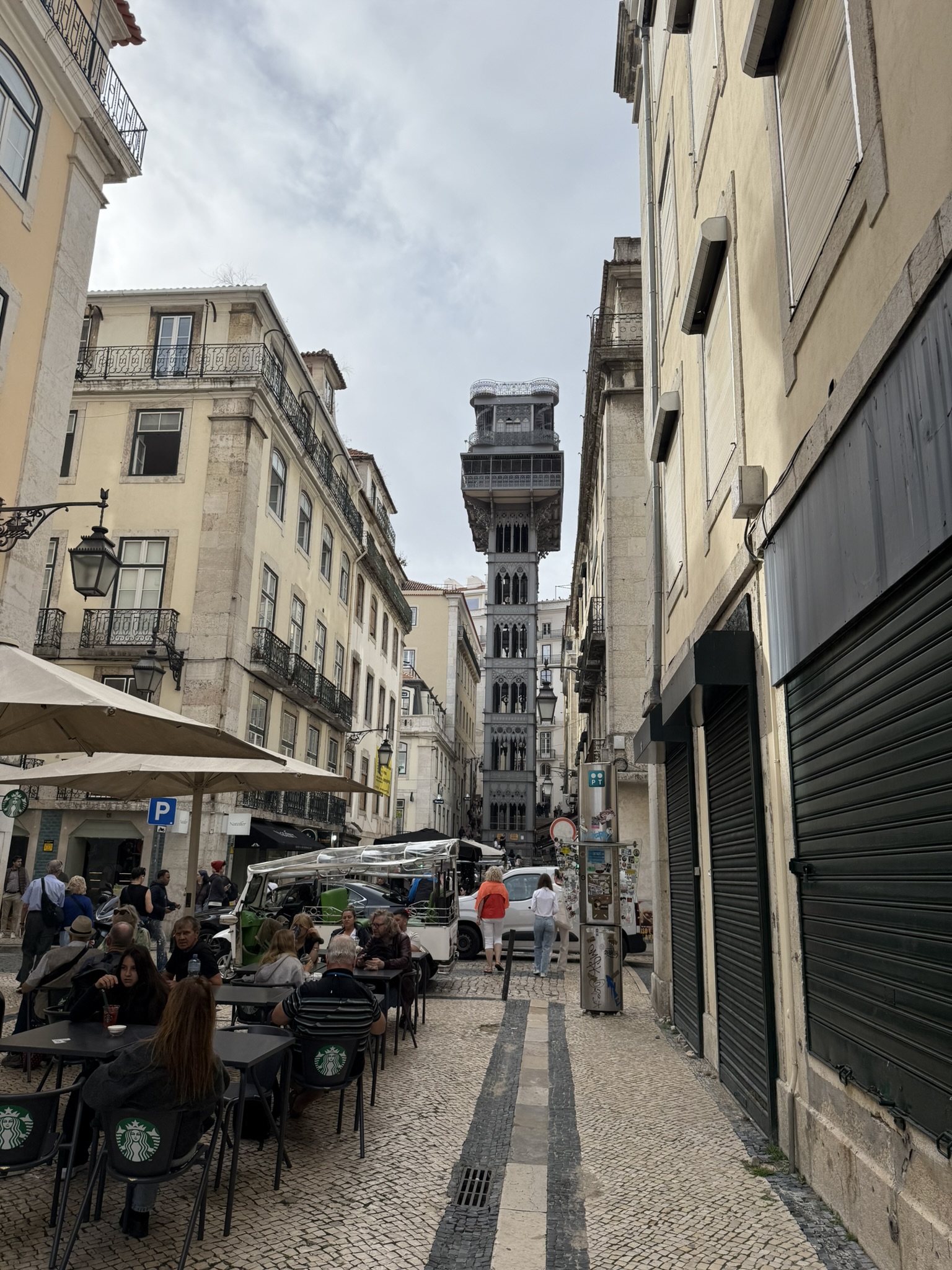 View down one of Lisbon's busier streets with outside elevator at the end of the street.