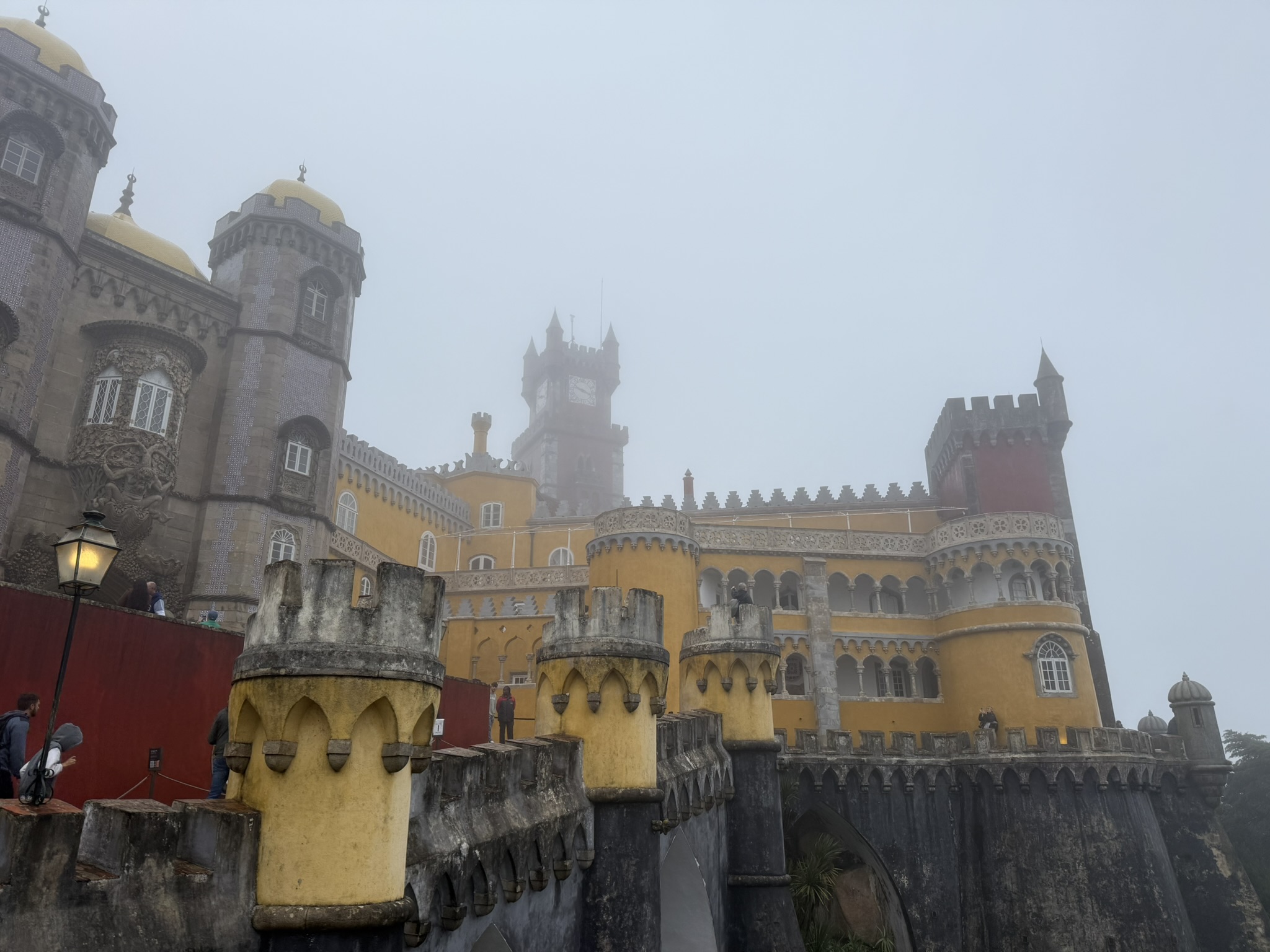 View of Pena Palace in Sintra, Portugal from the front on a very foggy and rainy day in best day trips from Lisbon