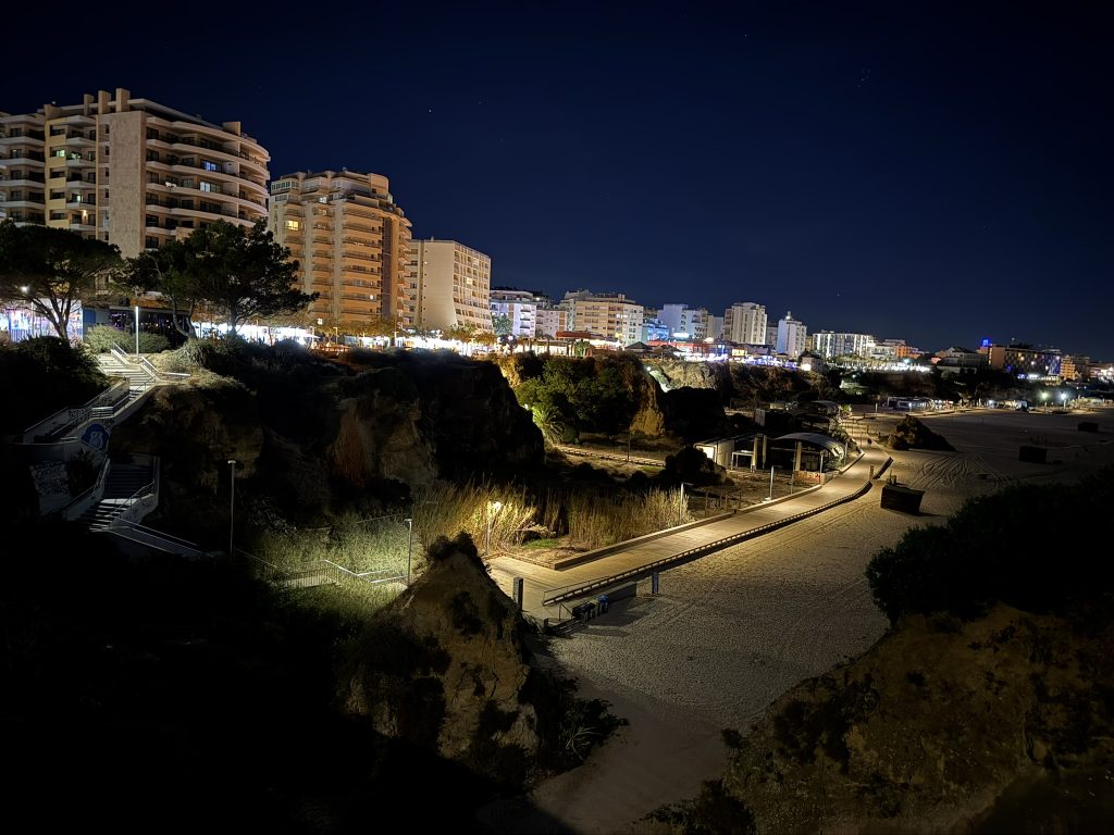 In the Algarve region of Portugal a  line of hotels and restaurants on a cliff above a beautiful beach  as seen at night on spring break in the Algarves