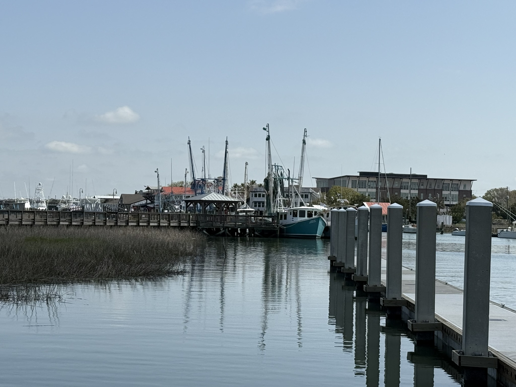 Spring break in Charleston, SC at Shem Creek in Mount Pleasant looking down the creek from the dock with all of the shrimp and fishing boats on calm water