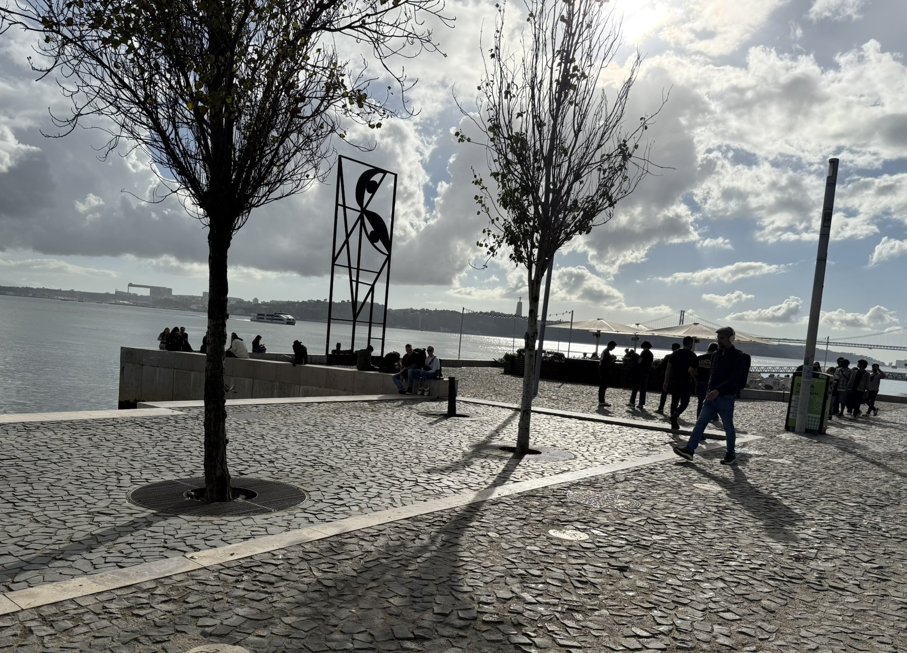 People walking by the Tagus river in Lisbon, Portugal on a November day as seen in best hotels in Lisbon with river views