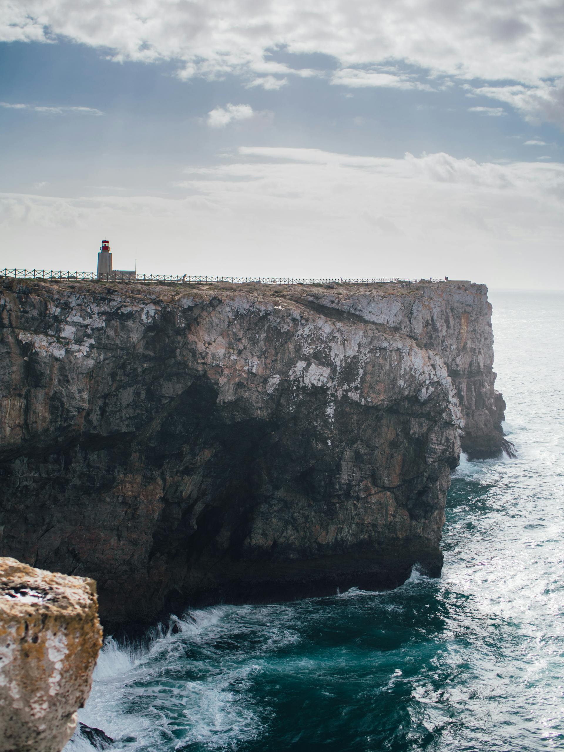 Breathtaking view of Sagres lighthouse perched on a dramatic cliff in Portugal, overlooking the ocean as seen on spring break in the Algarve region of Portugal