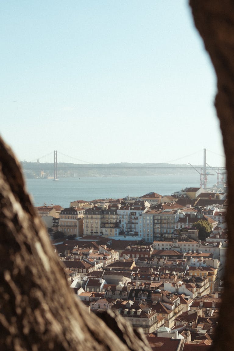 A breathtaking view of Lisbon, Portugal's cityscape with the iconic 25 April Bridge in the background as seen in best hotels in Lisbon for couples
