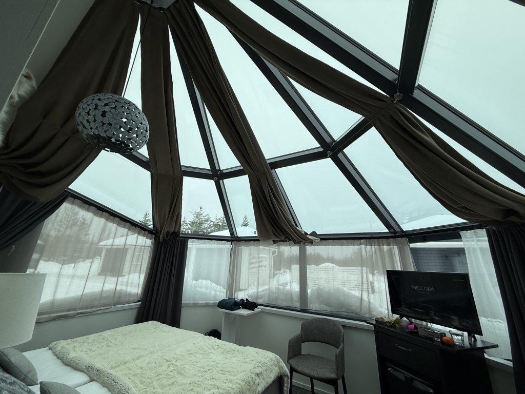 View from the inside of Santa's Igloos Arctic Circle where you can see the sky through the glass windows and ceilings in travel guide to lapland