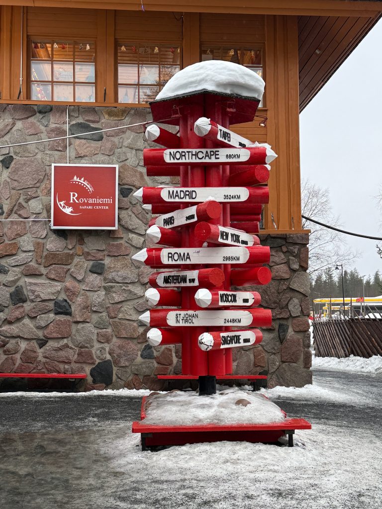 Sign in Santa's Village in Finland that shows how far away different cities are as seen in travel guide to Lapland, Finland