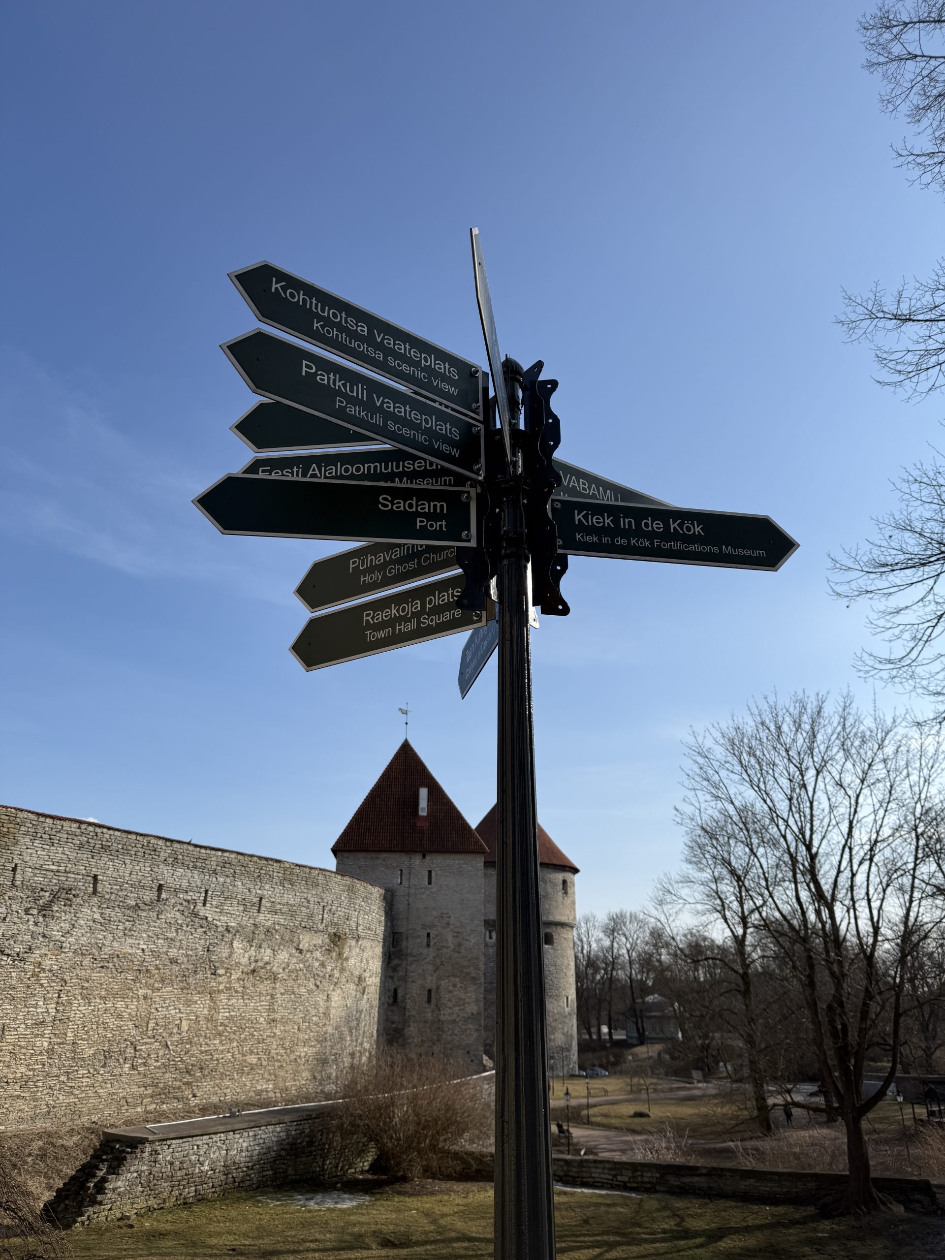 On the 2 days in Tallinn Itinerary a sign by the inside of the medieval wall that points in all directions and tells how far away different things are in Tallinn, Estonia