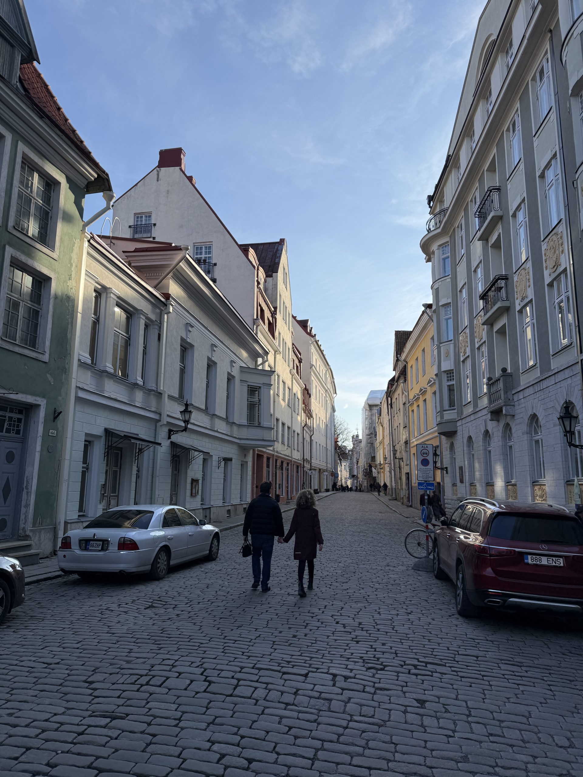 Two people walking hand in hand down a cobble street in the Old Town of Tallinn, Estonia during the 2 days in Tallinn itinerary overview