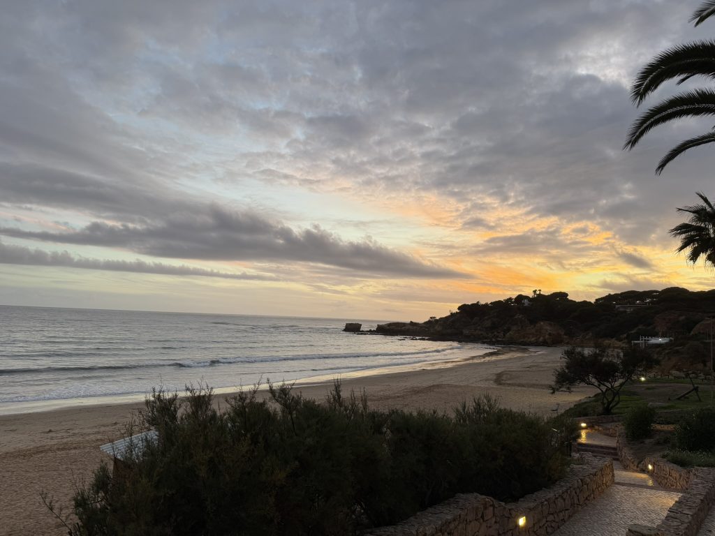 View of the ocean and beach right after the sun has set from a resort in Albuferia, Portugal in the best Algarve resorts