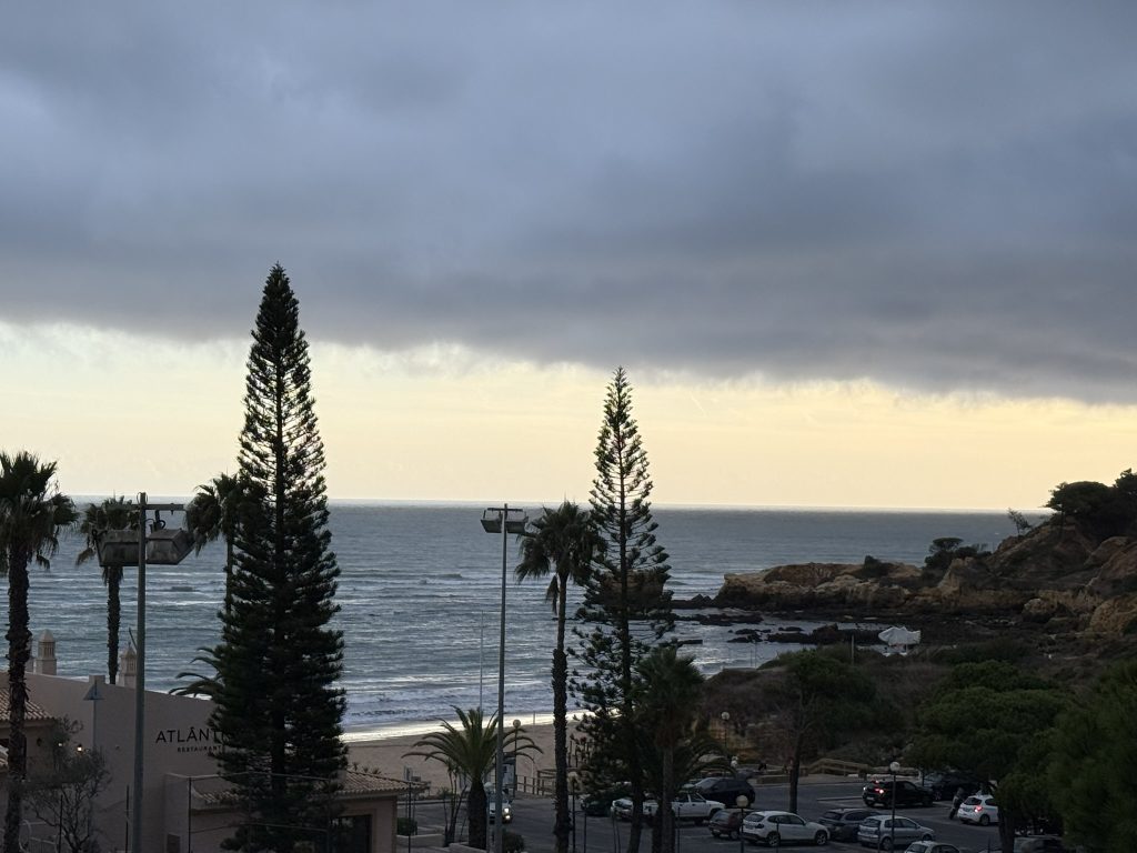 View from the balcony of the best Algarve resorts in Albuferia, Portugal right after the sun has set. The beach and ocean are in the distance on a still and romantic evening