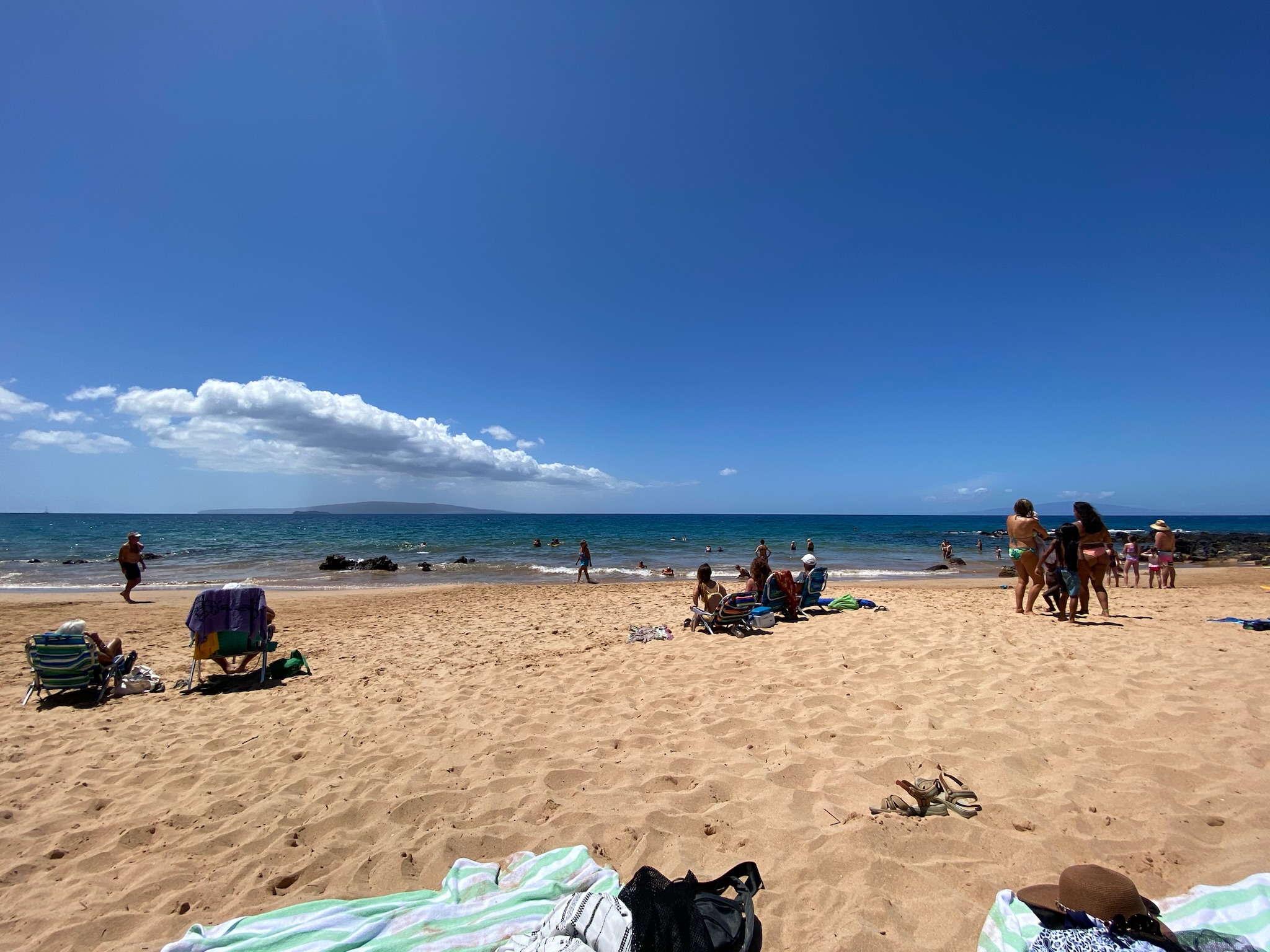 Sitting on the beach with the beautiful sand and clear blue sky in Maui, Hawaii in things to do in Maui for couples