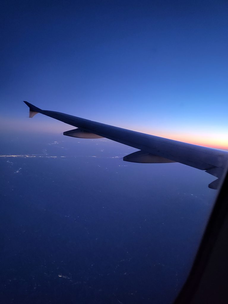 View from the plane window of a blue sky almost after the sun has completely set while flying into Los Angeles while planning your LA 2028 Olympic Trip