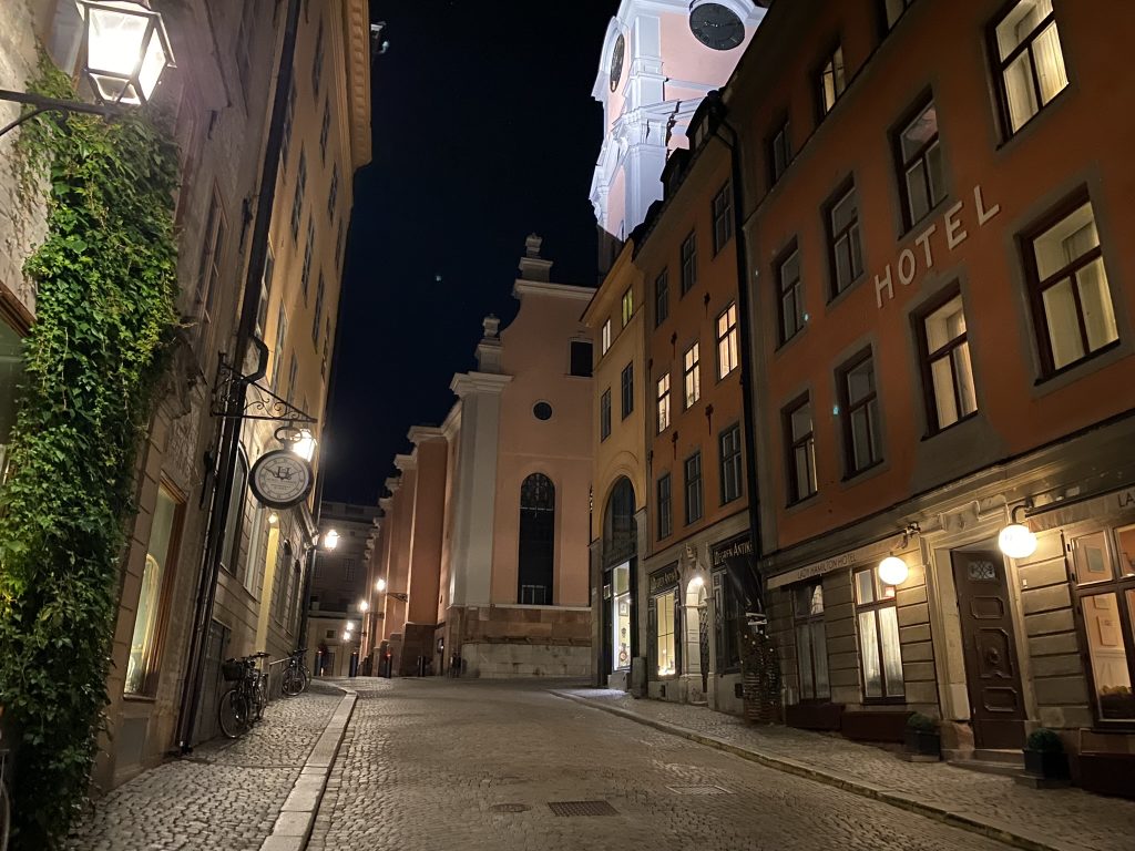 An empty old Seville street at night as seen in gathering travel tips with historic European buildings lining each side of the cobblestone street