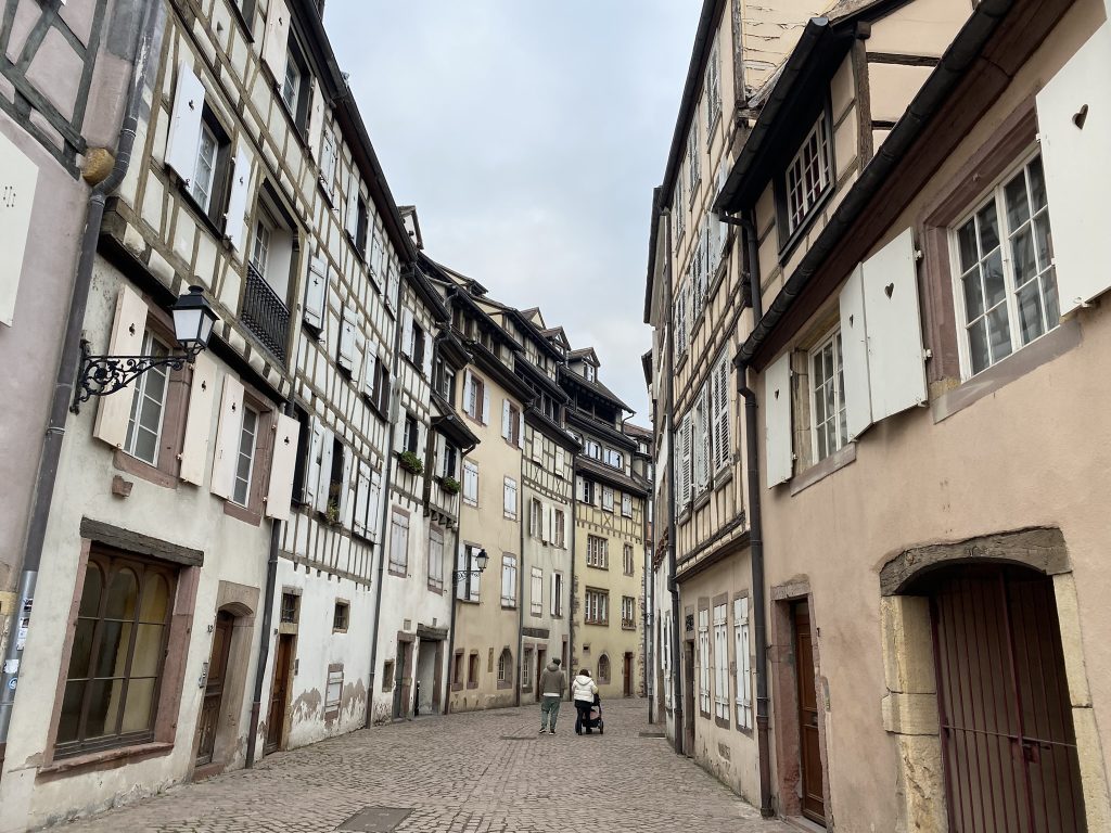 As seen in travel tips, an old alley way in Colmar, France aligned with European style buildings on both sides