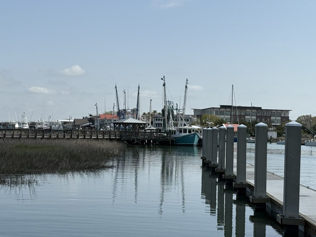 Walking down the pier in Shem Creek Park you can see out onto Shem Creek, which is lined with fishing boats, restaurants and marsh grass.