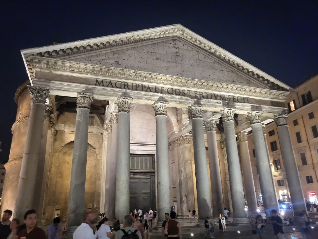The Pantheon at night with a crowd in front of it. This is one of Rome's most iconic and best-preserved ancient monuments