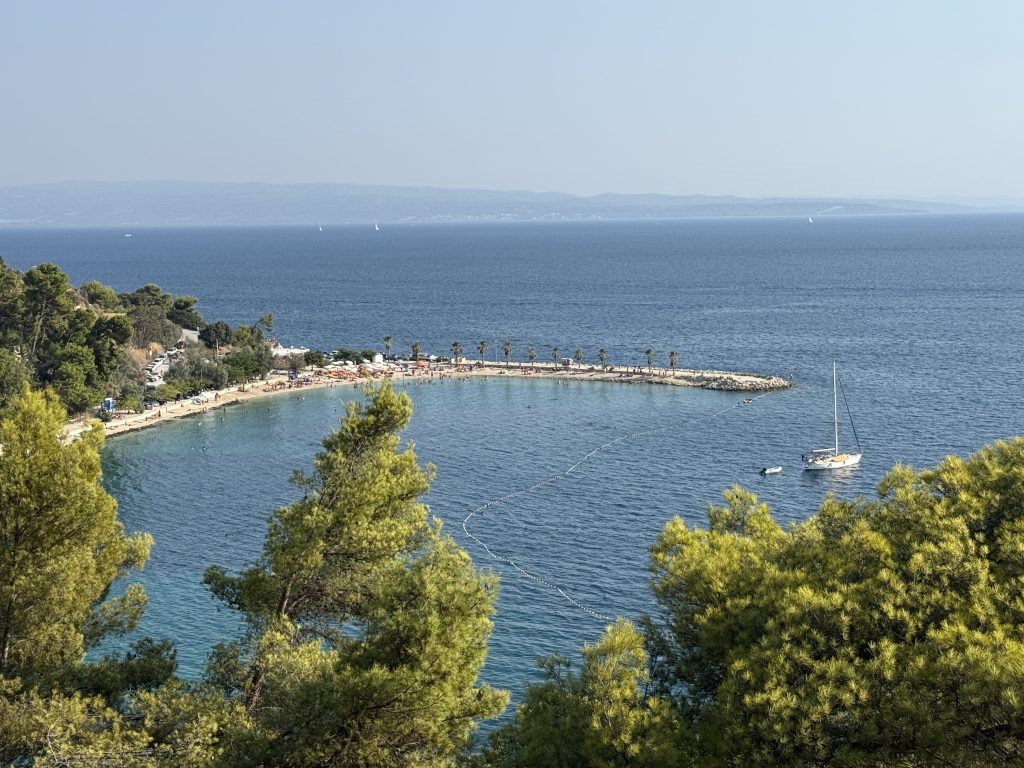 Aerial view of Kašjuni Beach on Marjan Hill with a sailboat anchored in the bay