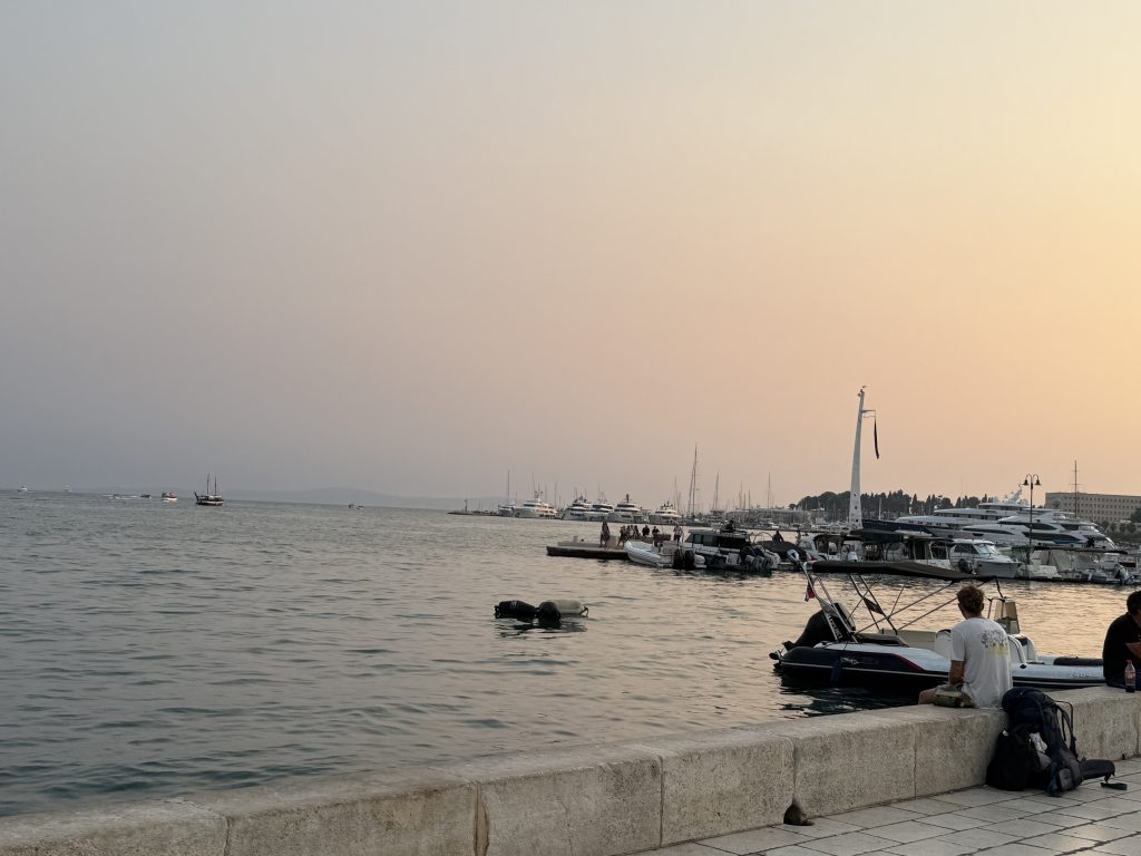 Sunset over Split harbor with boats and yachts, seen from the Riva seawall