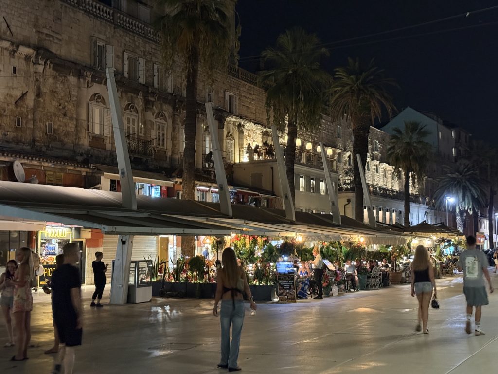 Riva Promenade restaurants glowing at night under palm trees in Split, Croatia